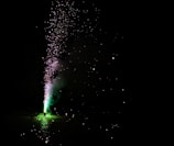 A vibrant burst of neon green sparks exploding against a black sky.