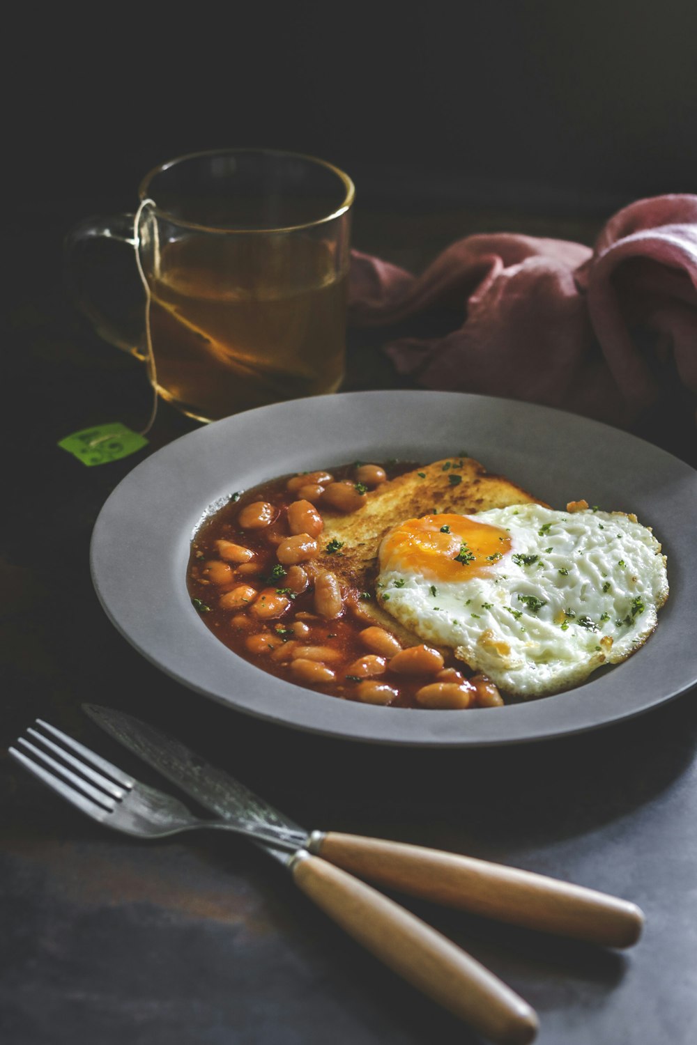 fried rice, beans, and tea with knife and fork