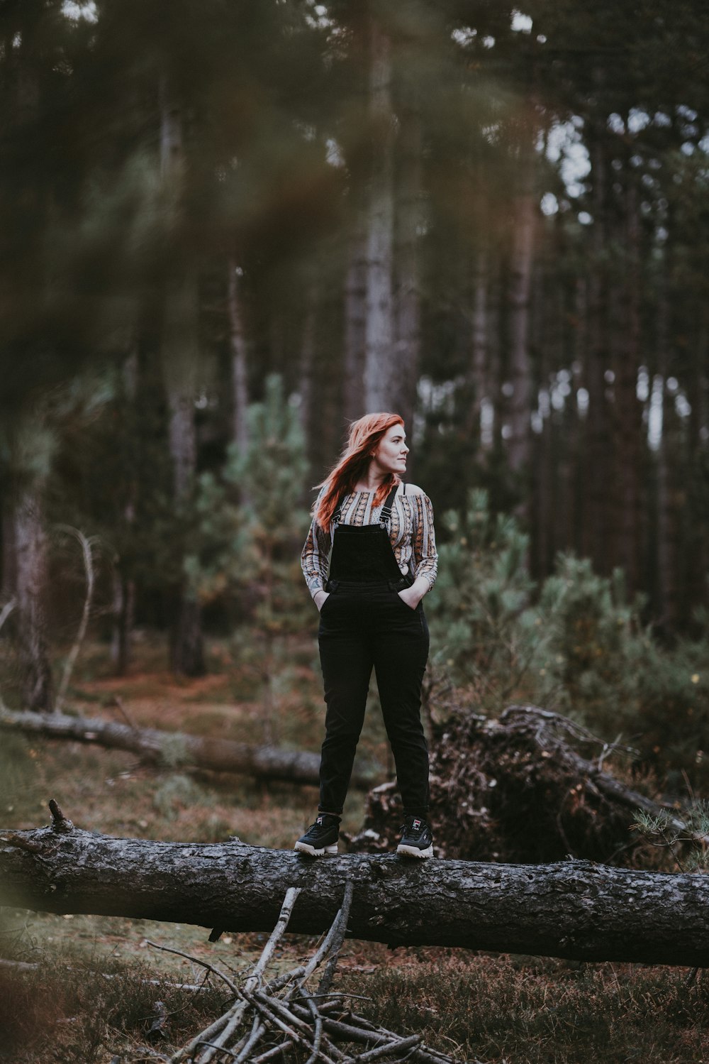 Frau steht auf Baumstamm im Wald