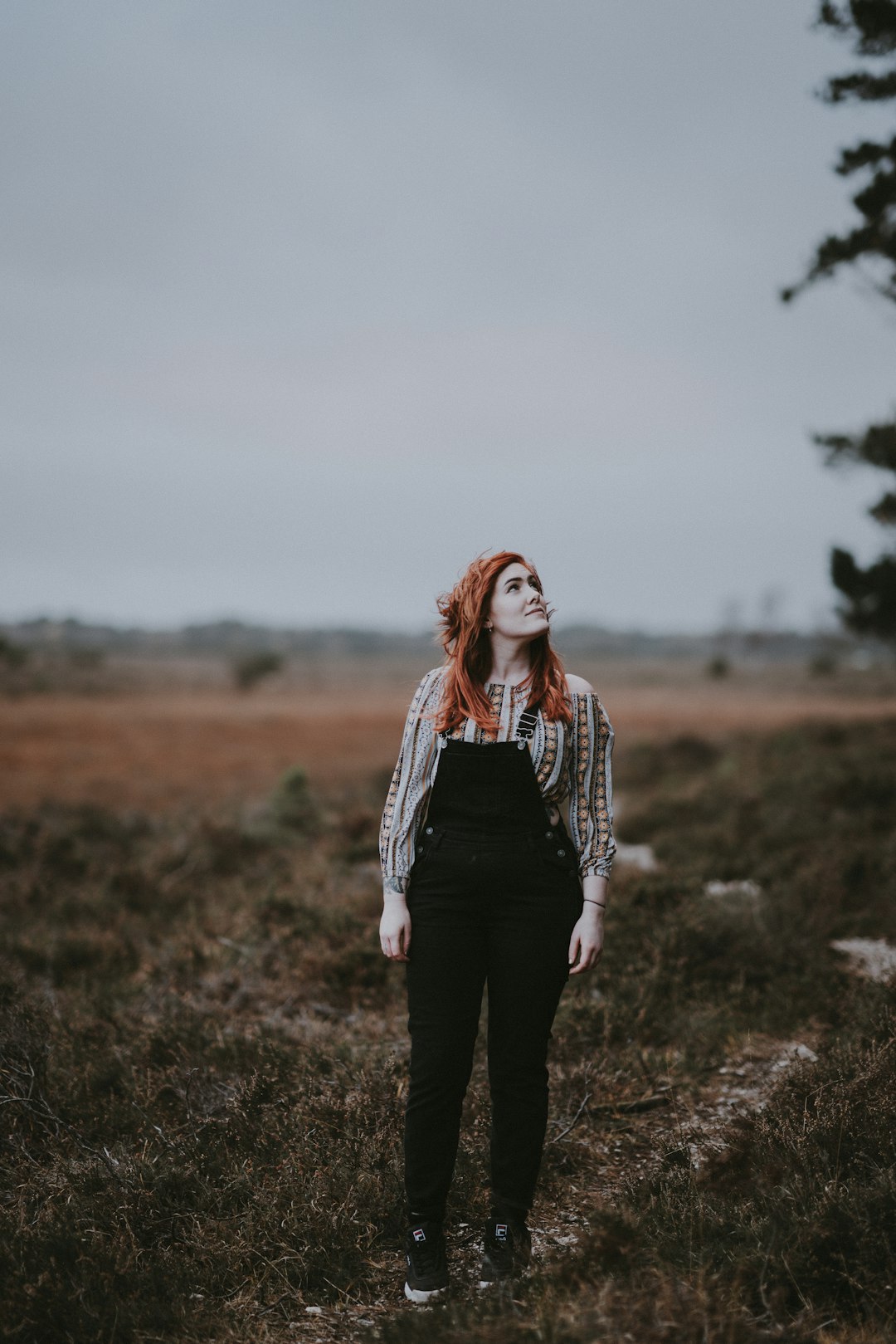 photo of woman looking above wearing black dungaree