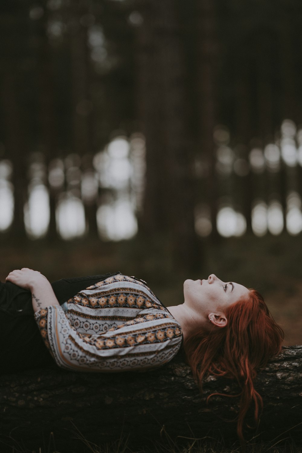 woman lying on tree trunk during daytime