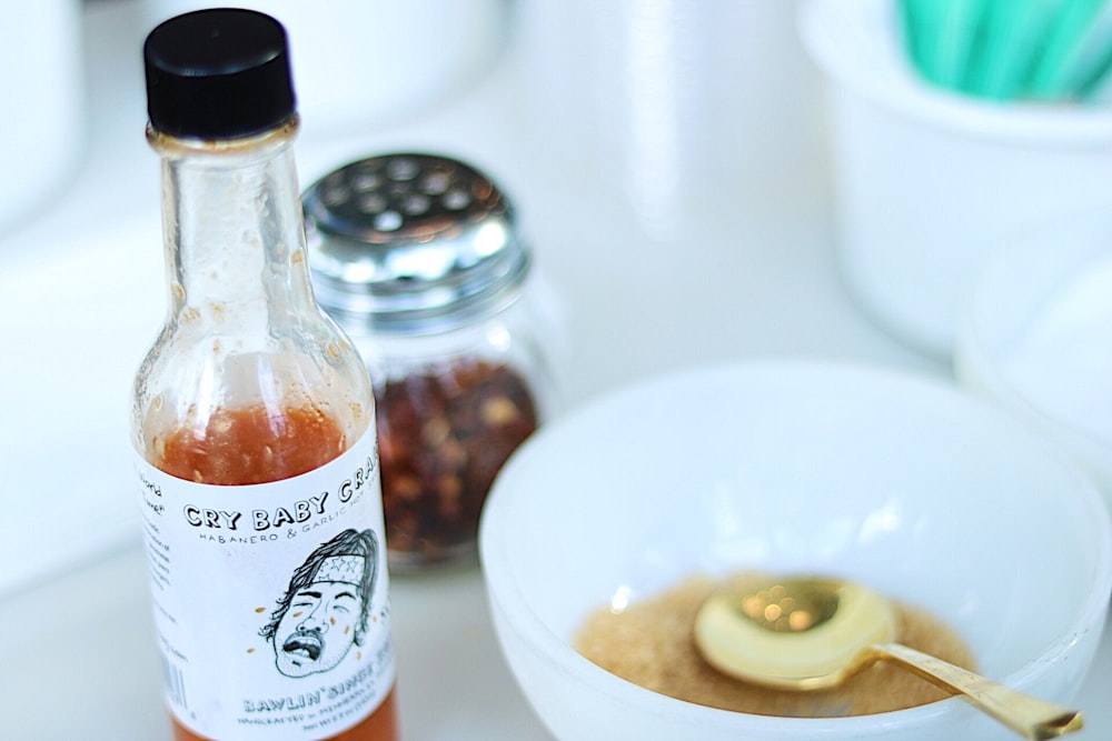 Cry Baby hot sauce beside white ceramic bowl