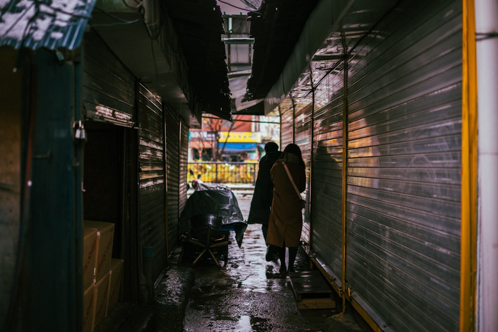 two persons standing between narrow pathway