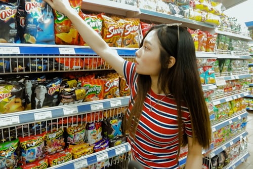 woman standing while grabbing plastic pack