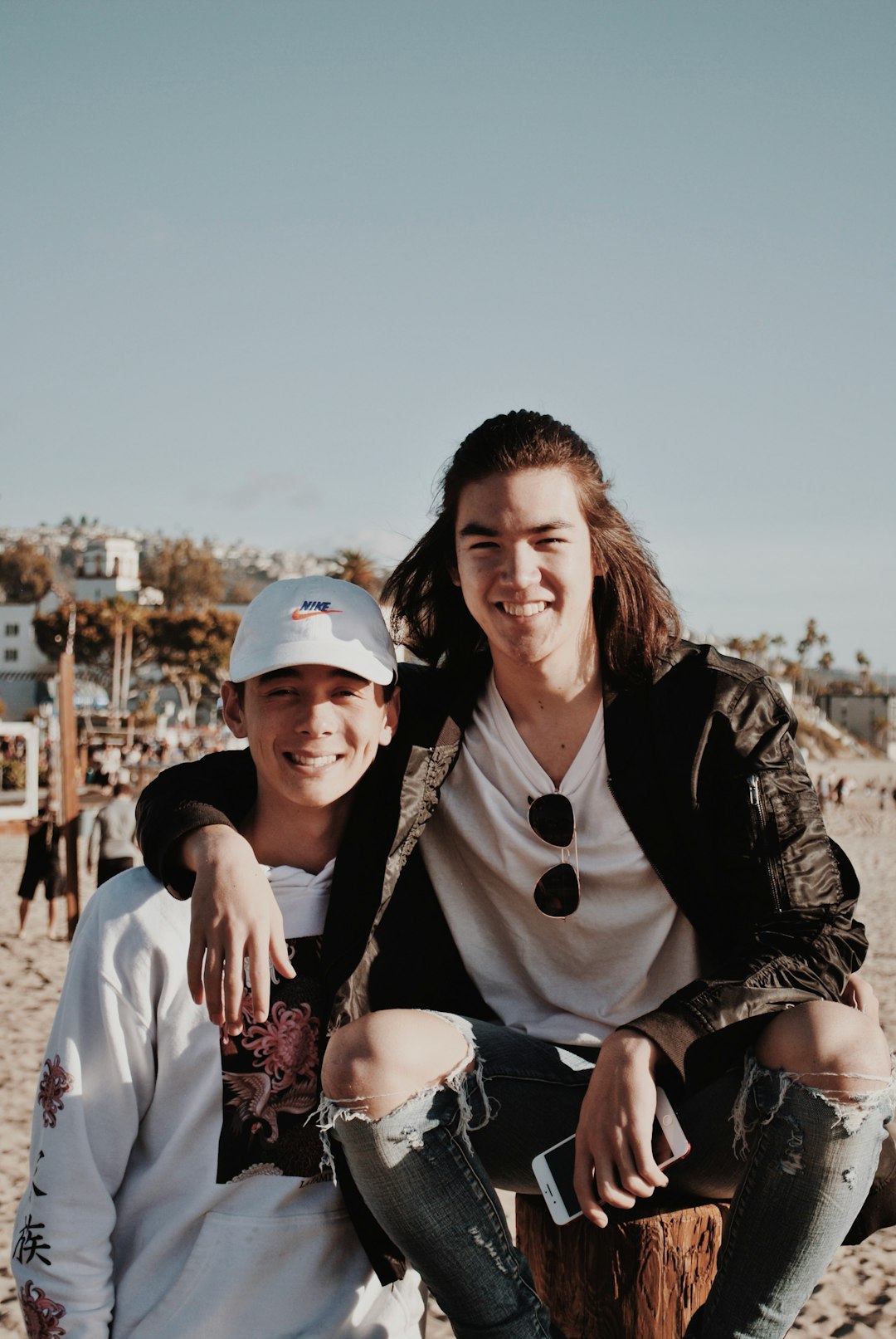 man in black jacket beside boy in white crew-neck long-sleeved shirt