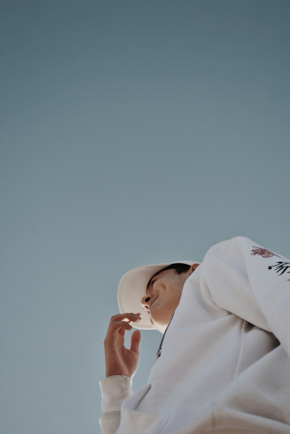 low angle photography of man wearing white cap