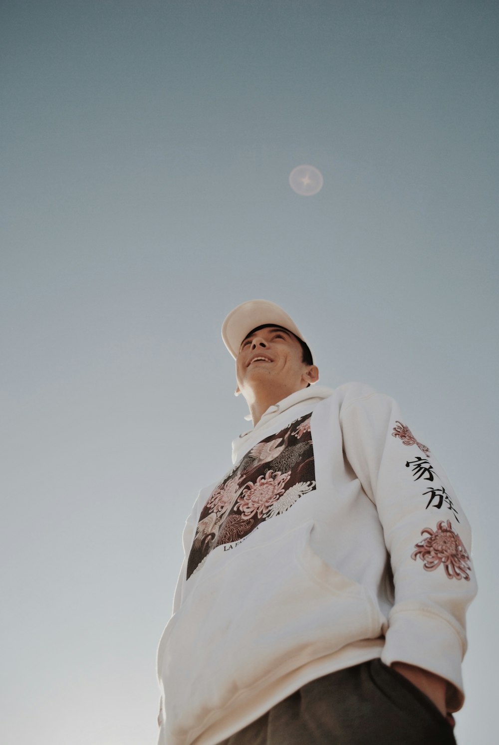 low angle photography of man smiling wearing fitted cap