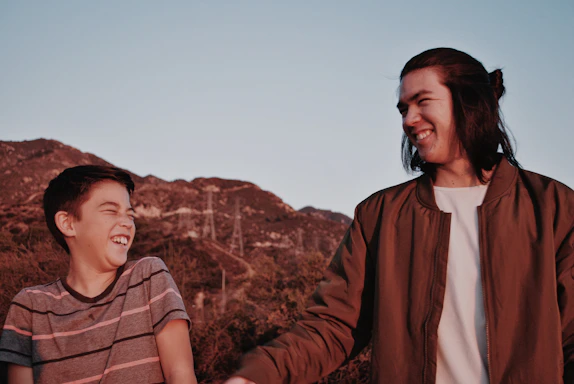 A warm, candid photo of a couple laughing together during a sunset portrait session.