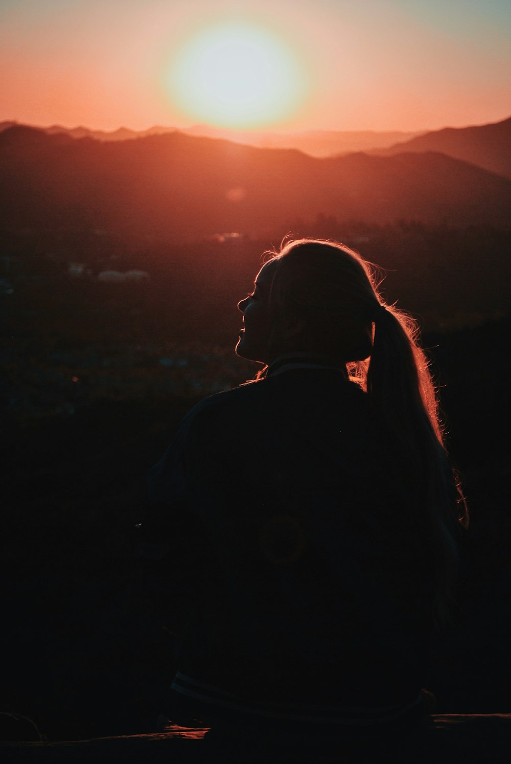 femme en veste debout sur la colline