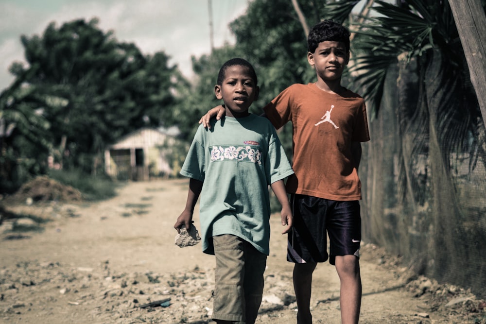 two boy walking on footpath