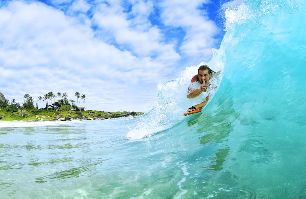 surver riding wave during daytime