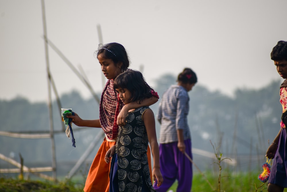 two girl walking near boy