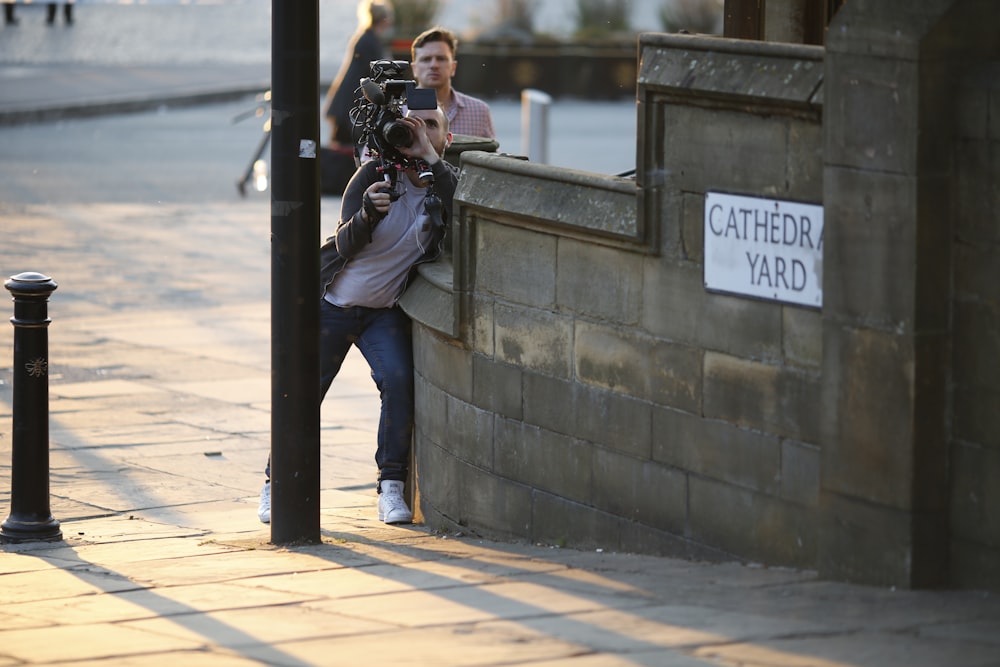 shallow focus photo of man using video camera