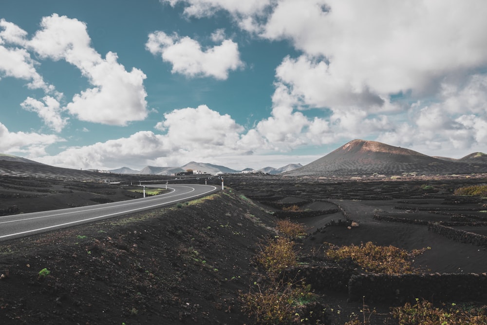 road far from mountain under white clouds