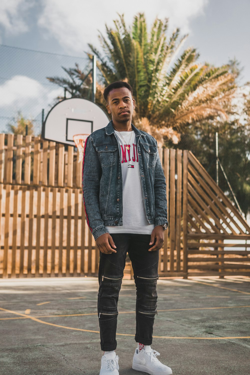 man wearing blue denim jacket near basketball system