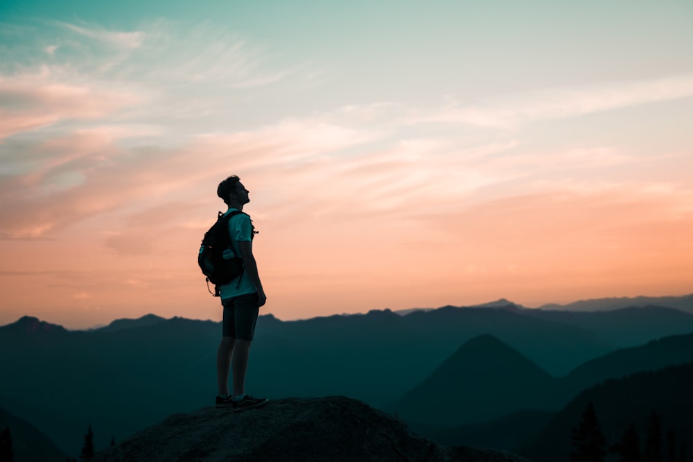 man in white tee shirt standing on hill