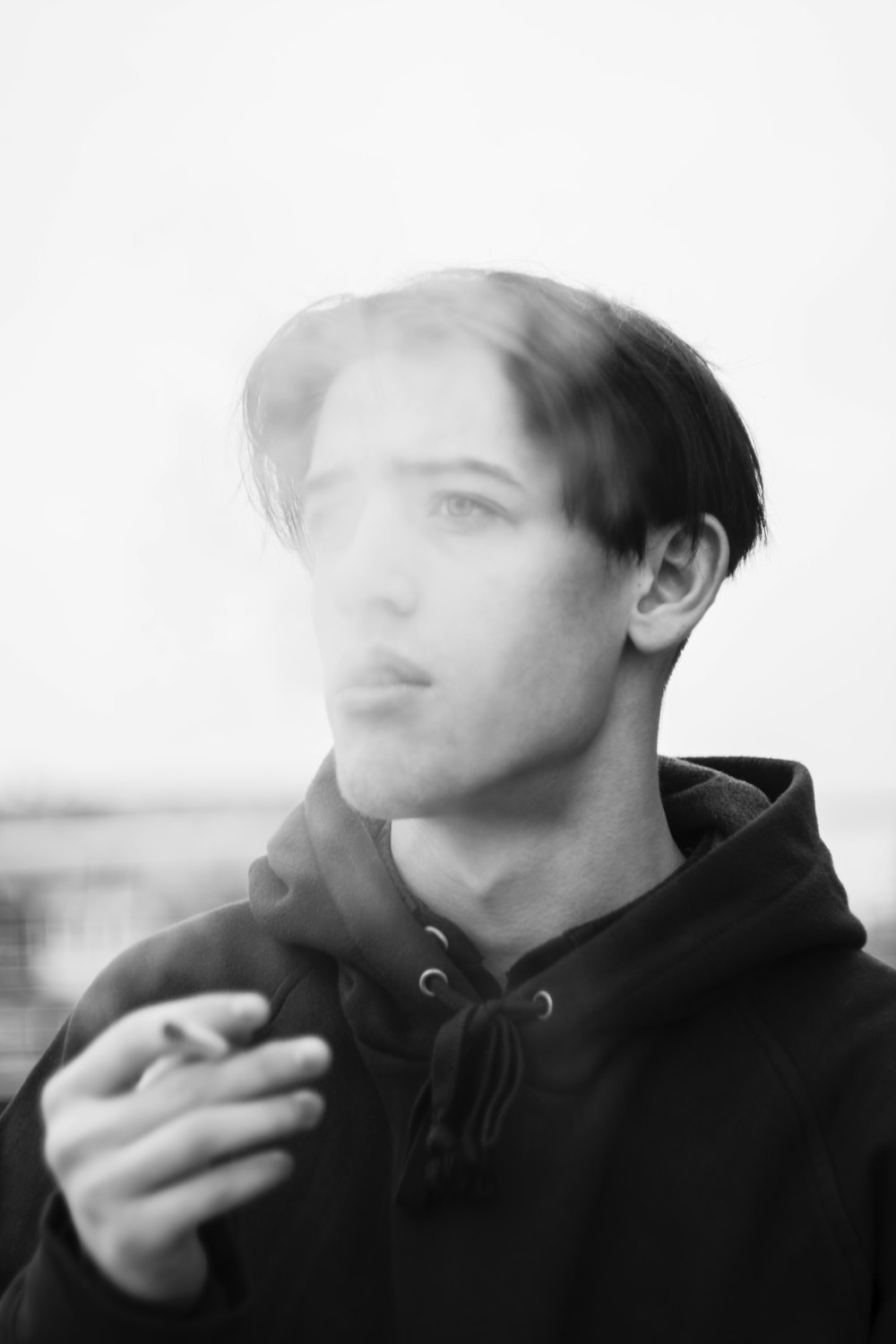 Photographie en niveaux de gris d’un homme fumant une cigarette