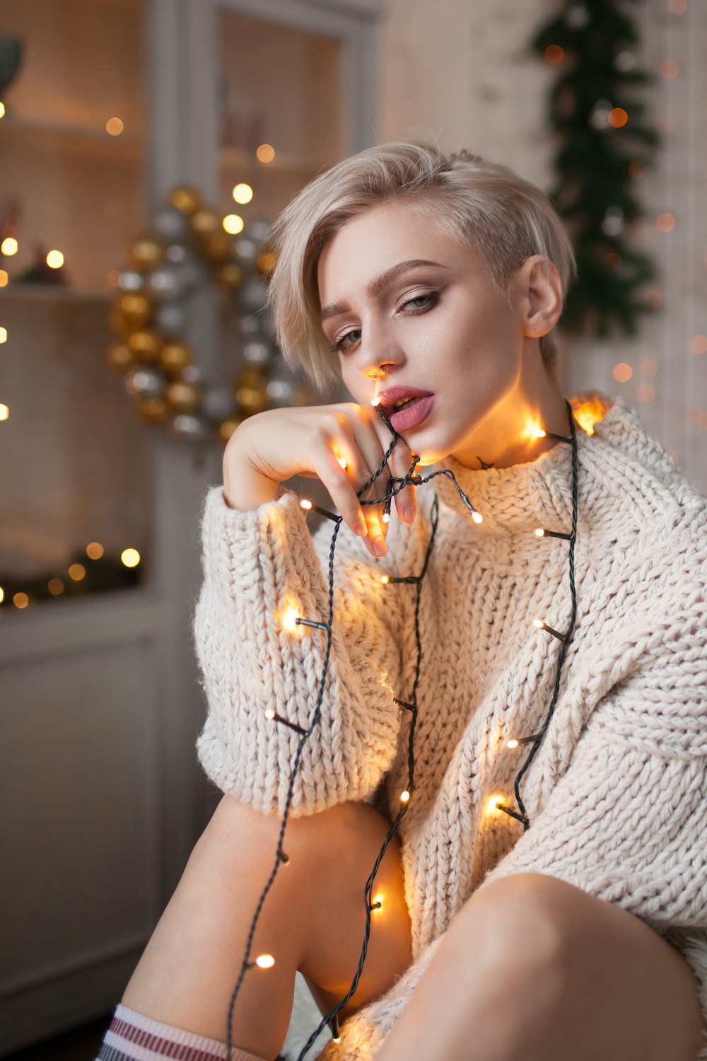woman in beige sweater with orange string lights on her body