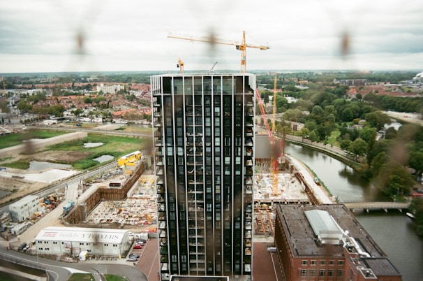 A modern building under construction with cranes in the background.