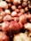 A close-up of fresh pomegranates stacked in a wooden crate.