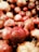 A close-up of fresh pomegranates stacked in a wooden crate.