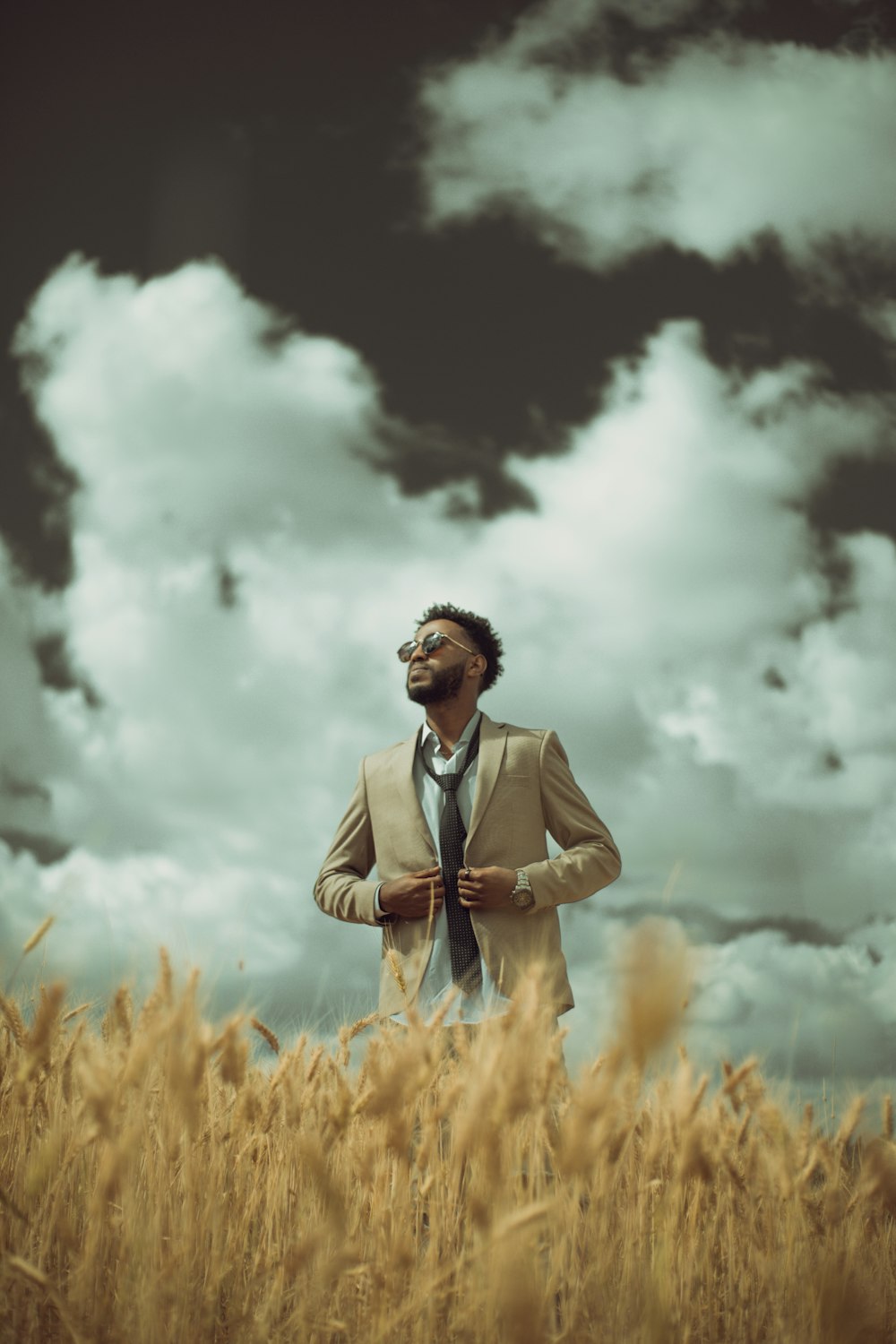 man wearing brown suit jacket standing on field