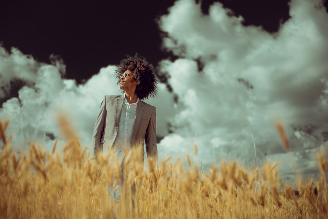 man standing on wheat field during daytime