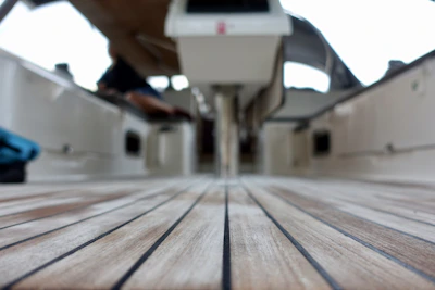Close-up of wooden textures and blue water tones on the floating barge's deck.