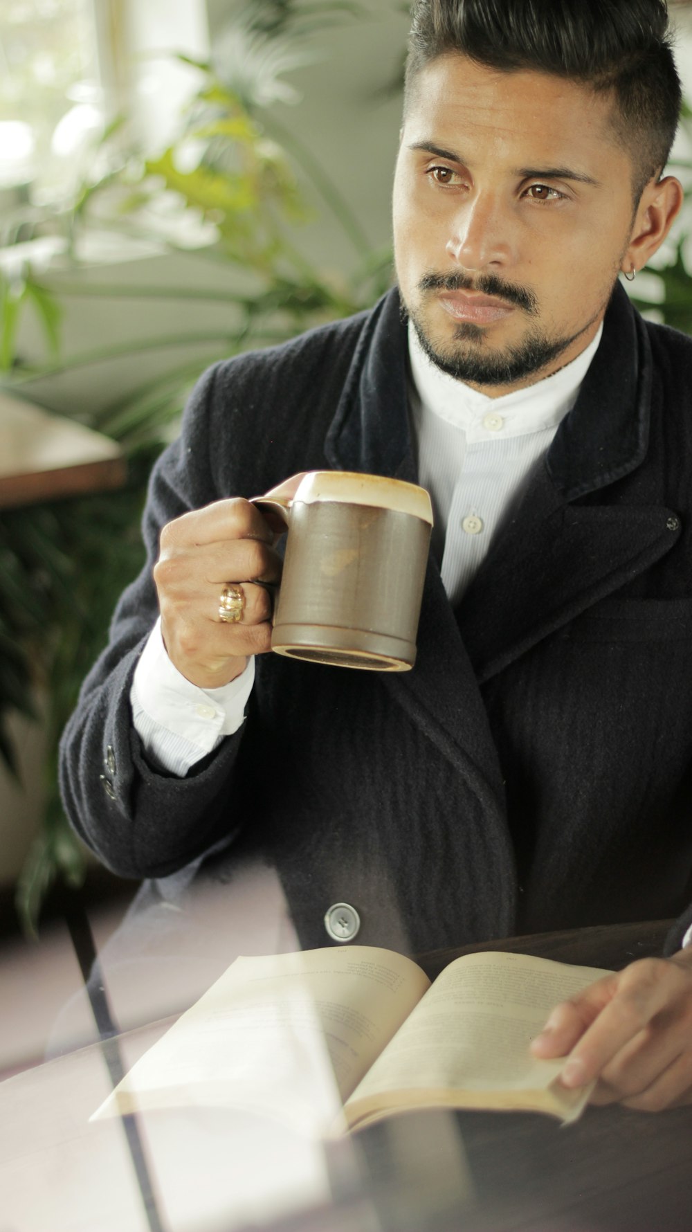 man holding brown mug