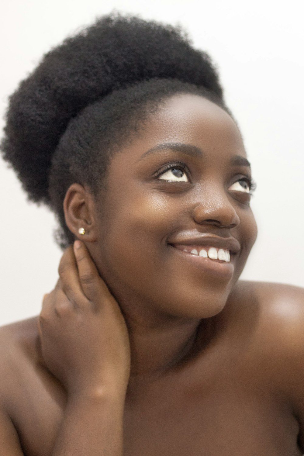 mujer sonriente sosteniendo su cuello