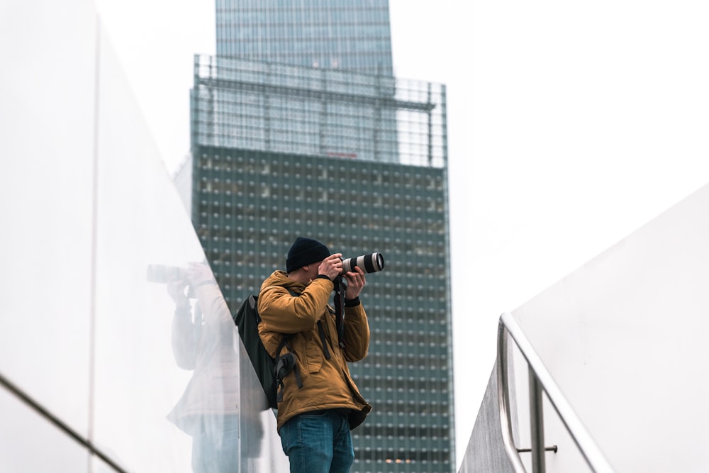 man taking picture near building a daytime