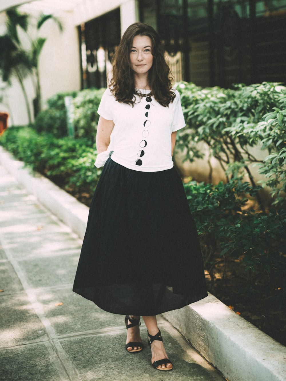 woman wearing black skirt standing beside plants