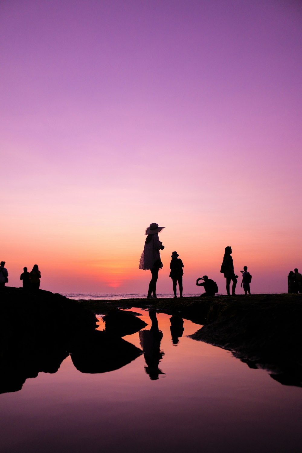 silhouette of people at shore during golden hour