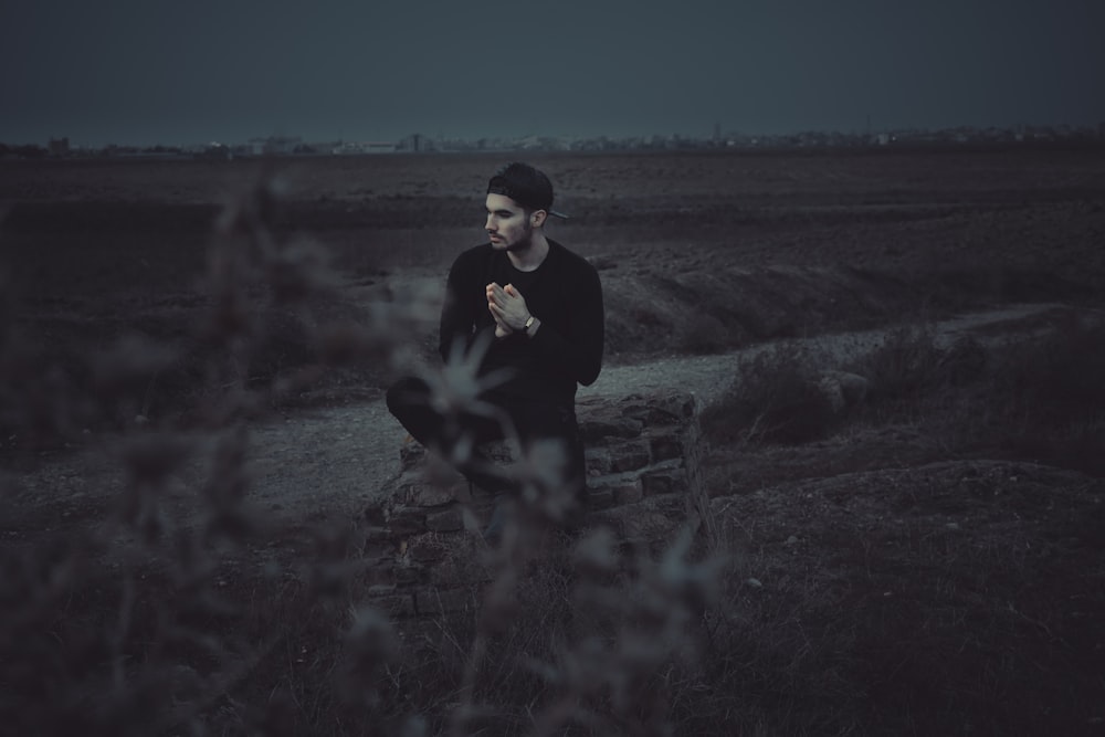 man sitting near the grass photography