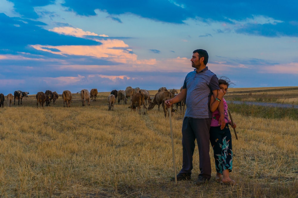 man and children standing in grass field during daytime