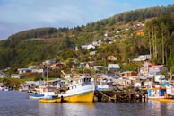 A cozy coastal village with colorful houses and boats docked by the shore.