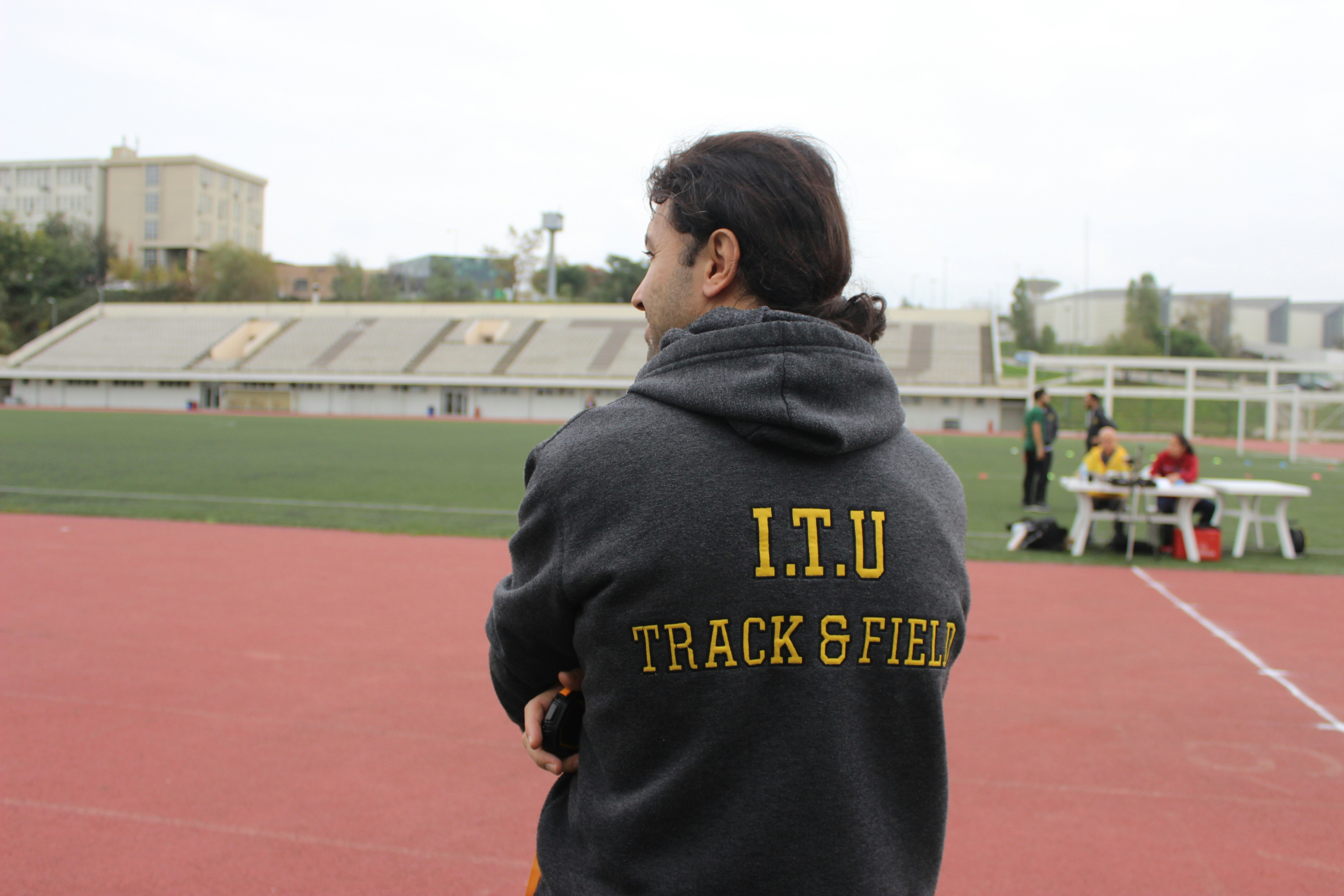 man in black and yellow hoodie front of field