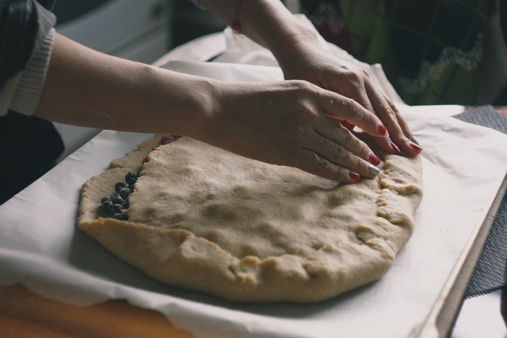 woman making dough on white textile