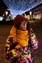 A nighttime city street scene with a person wearing a reflective jacket from drown & drip.