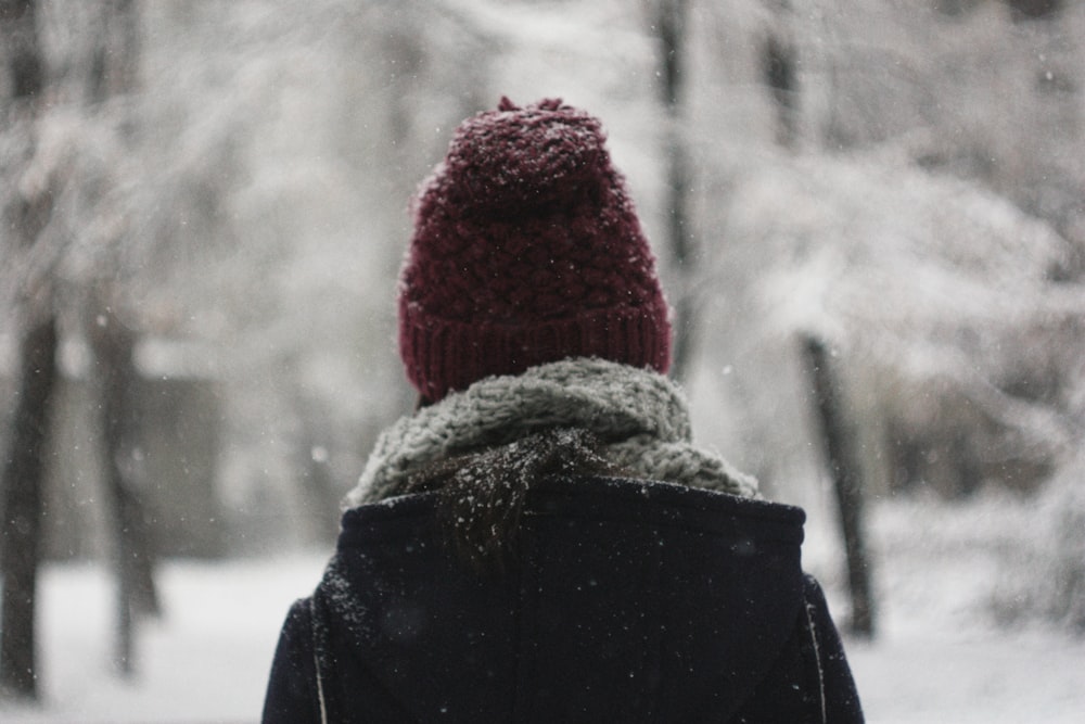 selective focus photography of person wearing red knit cap and black hoodie