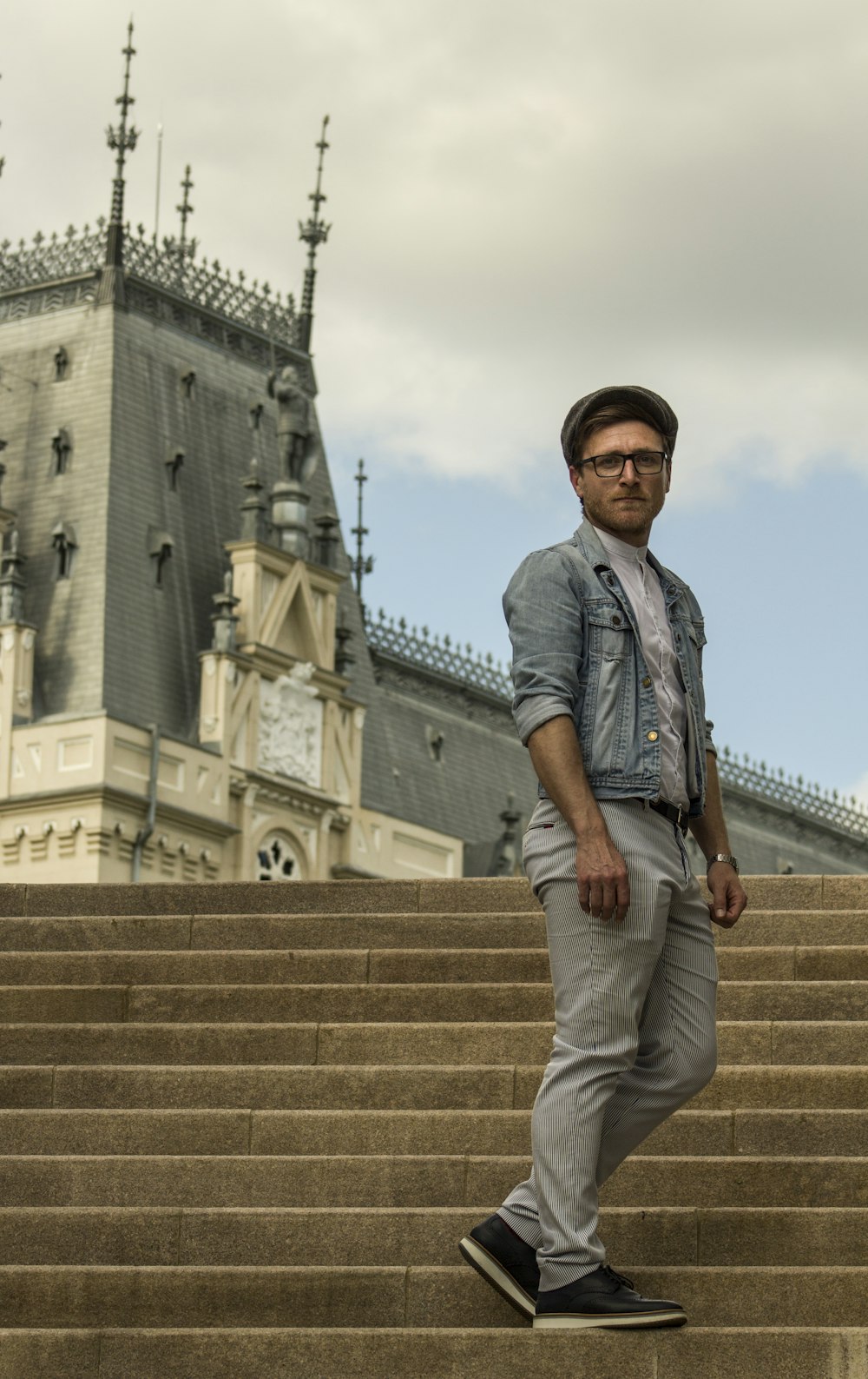 man standing on concrete stair near castle