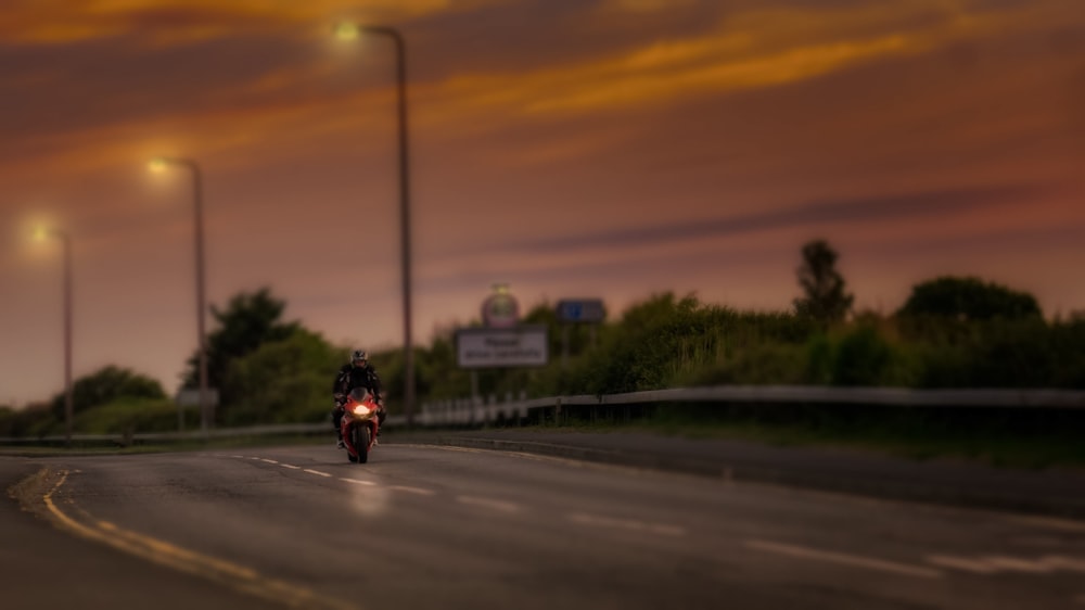 man riding sports bike on road during golden hour