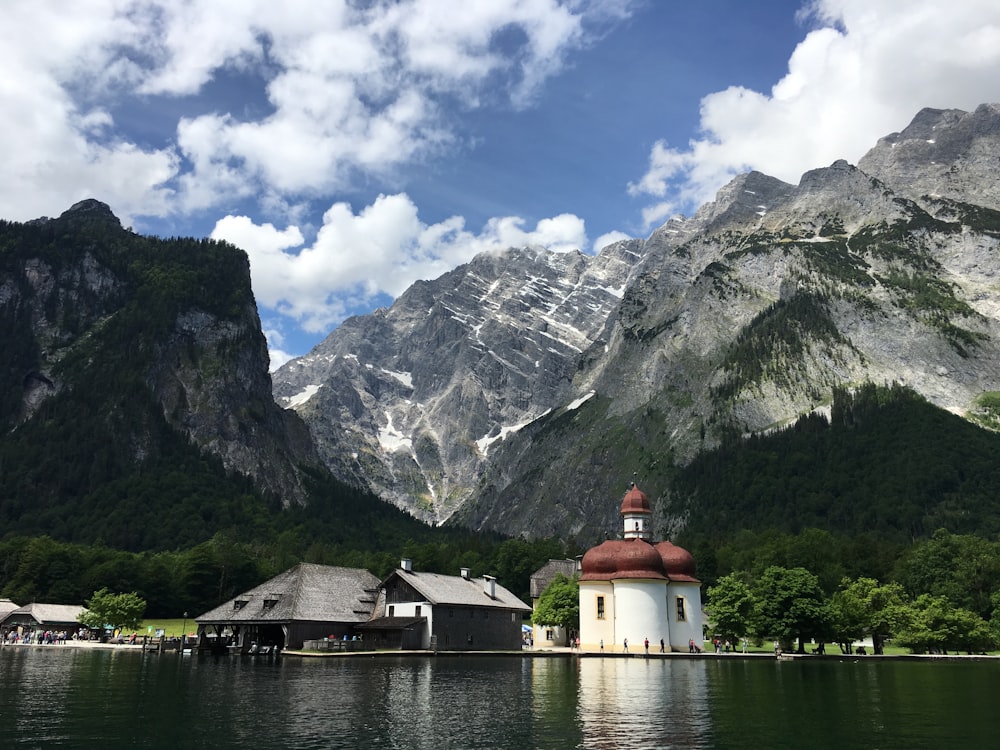 white lighthouse tower and gray shed by the lake