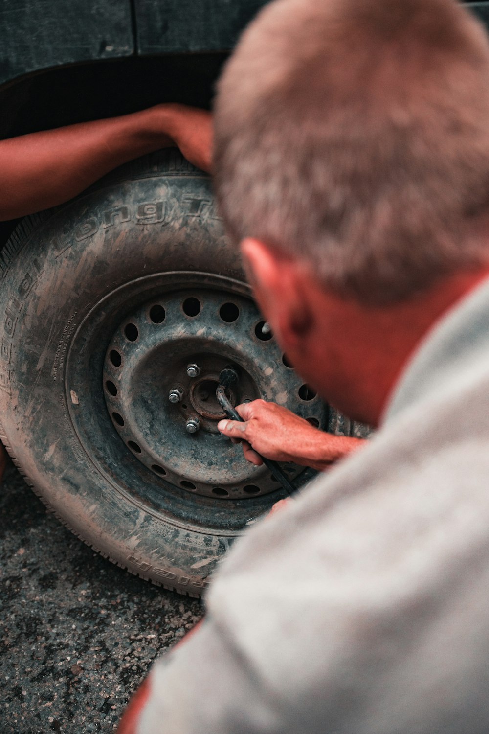 man fixing tire of vehicle