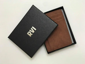 Elegant engraved leather wallet opened to show personalized initials.