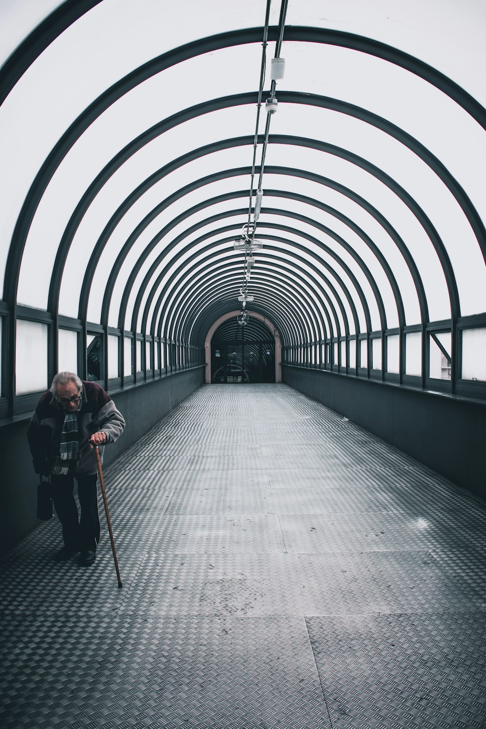 man using cane while walking on pathway