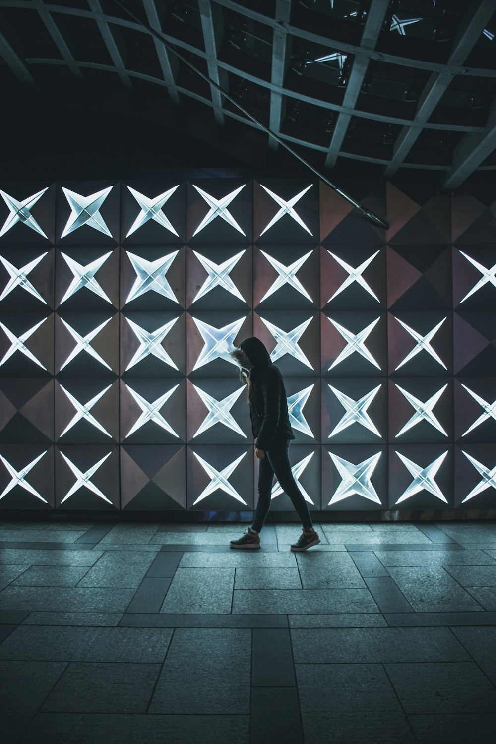 person walking inside building beside lighted wall