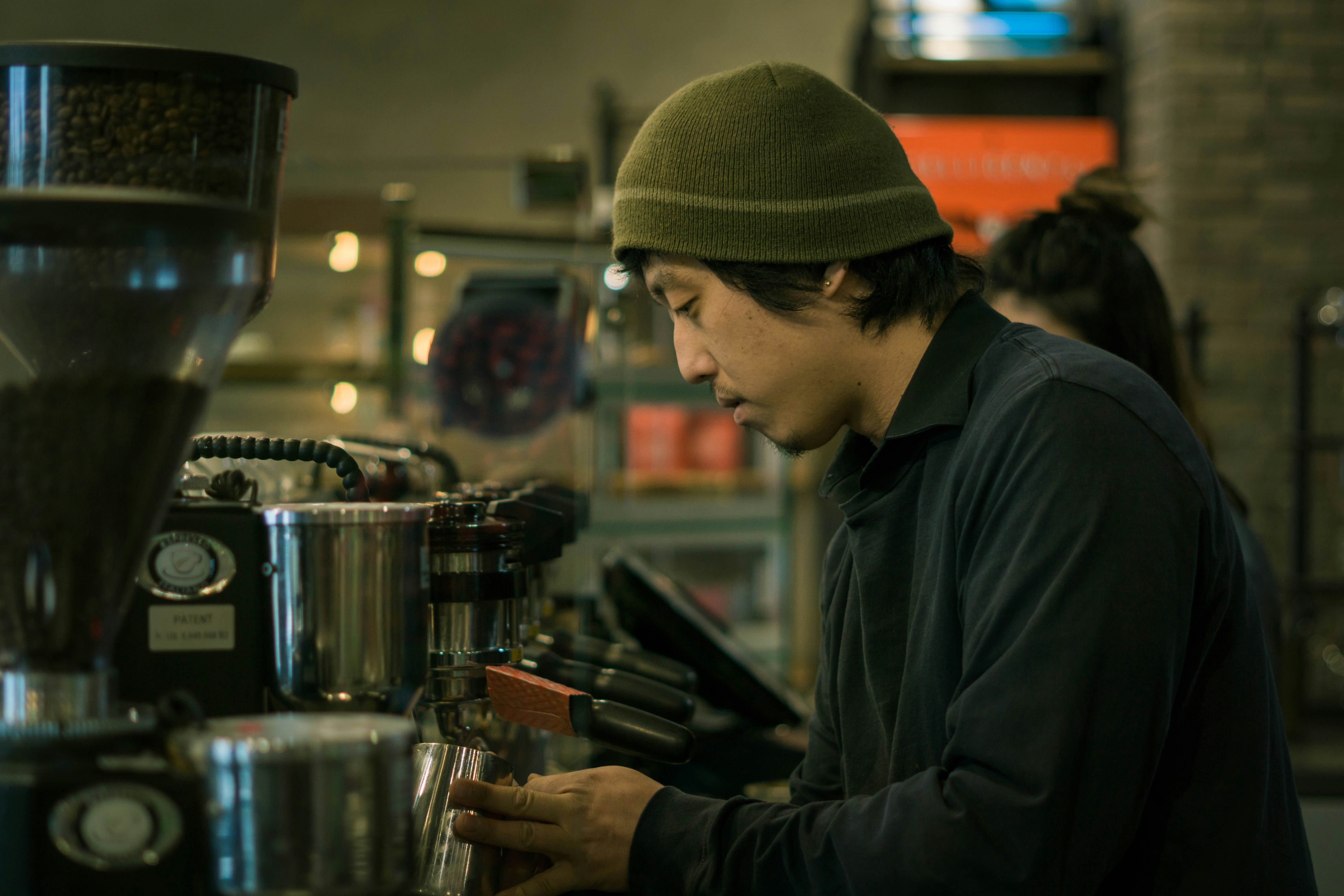 man standing and filling cup on machine