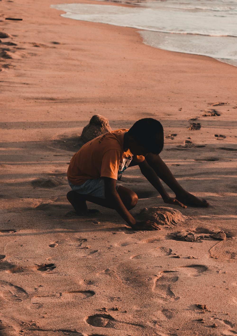 boy holding white sand during daytime
