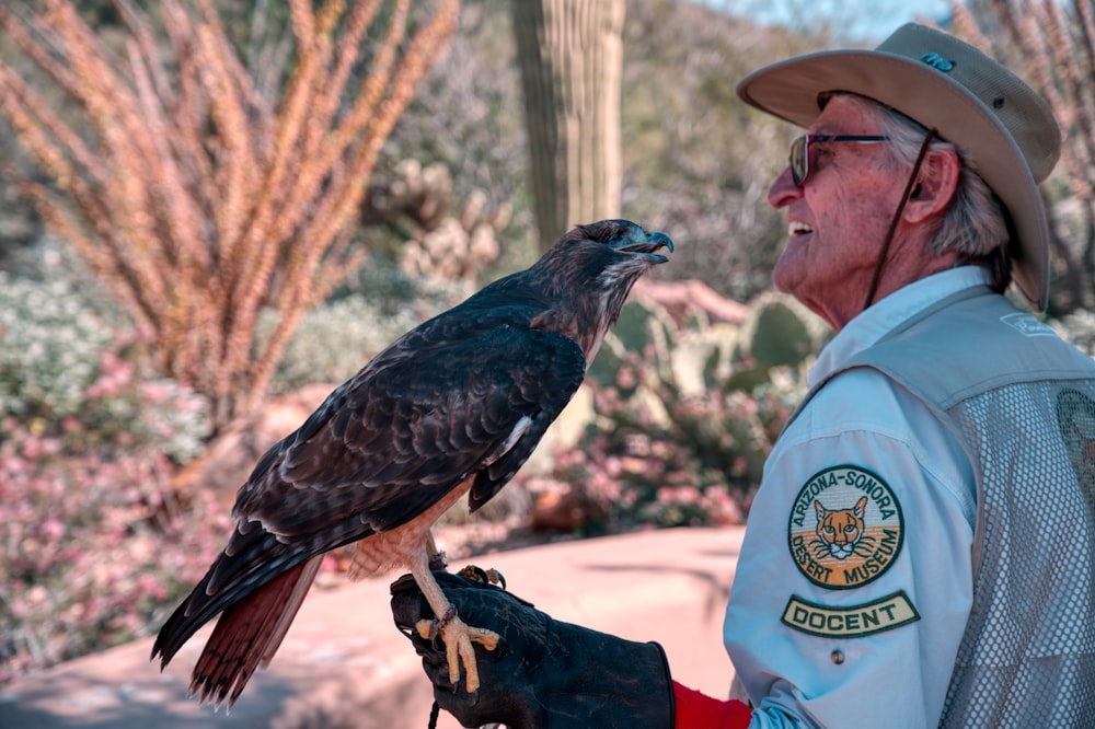 a man holding a bird of prey in his hand